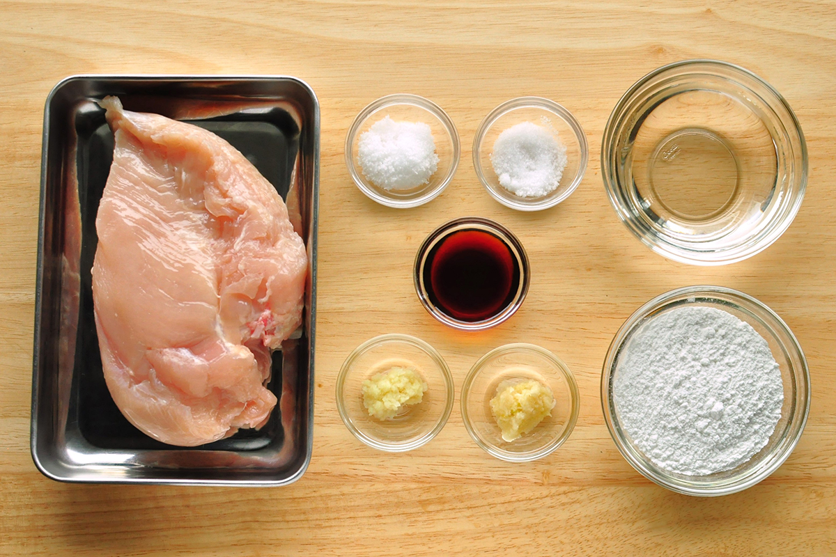 金属製バットに鶏むね肉と米粉から揚げで使う調味料が並べられている